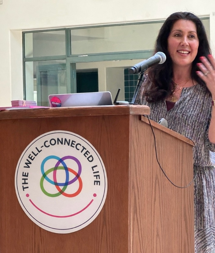 RS presenting The Well Connected Life at podium